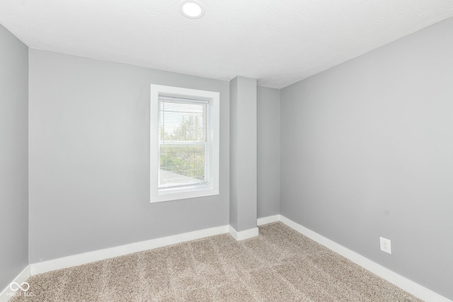 empty room featuring carpet and baseboards