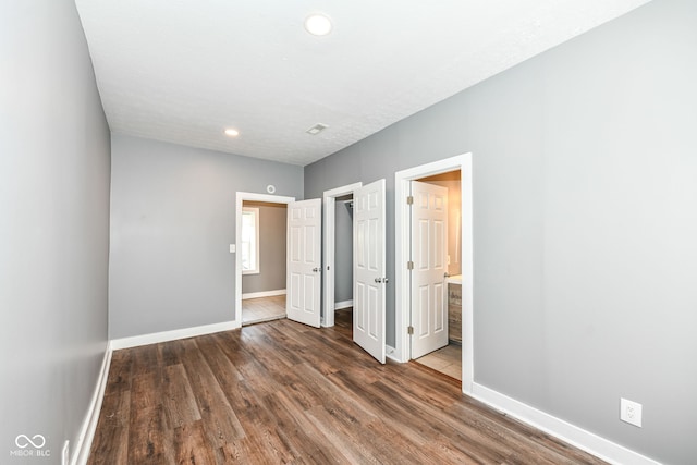unfurnished bedroom featuring connected bathroom, recessed lighting, wood finished floors, and baseboards