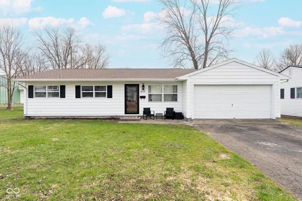 single story home featuring aphalt driveway, an attached garage, and a front yard