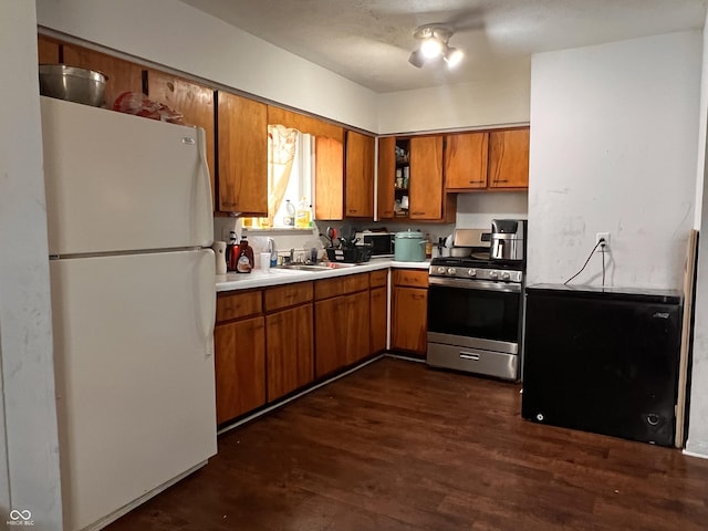 2194 N Riley Ave, Indianapolis, IN 46218 - kitchen featuring light countertops, a sink, gas range, brown cabinetry, and freestanding refrigerator