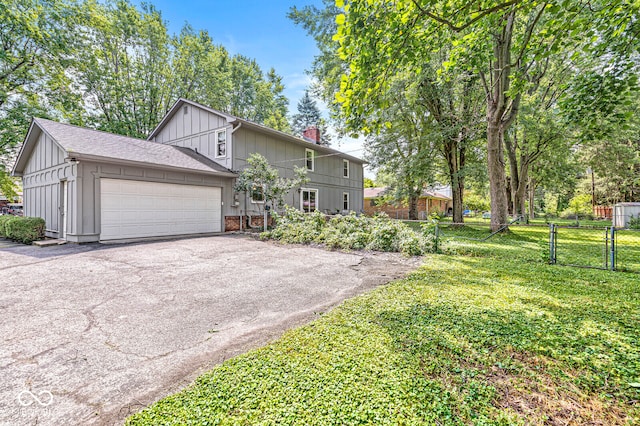 7138 Avalon Trail Ct, Indianapolis, IN 46250 - view of front facade featuring board and batten siding, driveway, an attached garage, a chimney, and a gate
