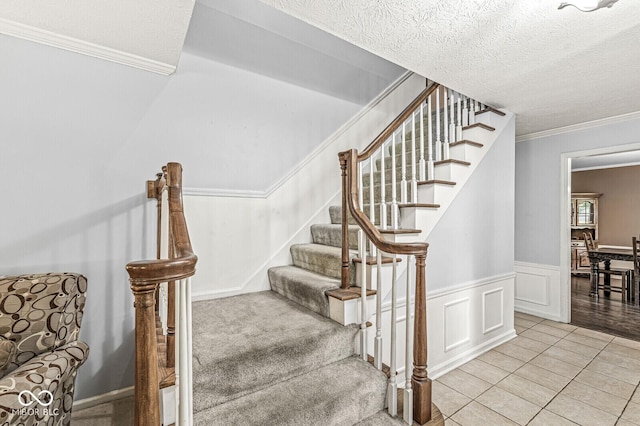 7138 Avalon Trail Ct, Indianapolis, IN 46250 - staircase featuring crown molding, a wainscoted wall, tile patterned flooring, a textured ceiling, and a decorative wall