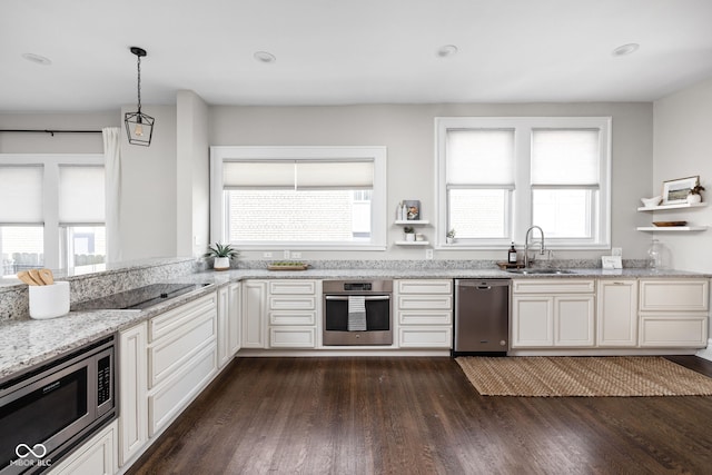 3447 Washington Blvd, Indianapolis, IN 46205 - kitchen featuring stainless steel appliances, a sink, dark wood finished floors, light stone countertops, and hanging light fixtures
