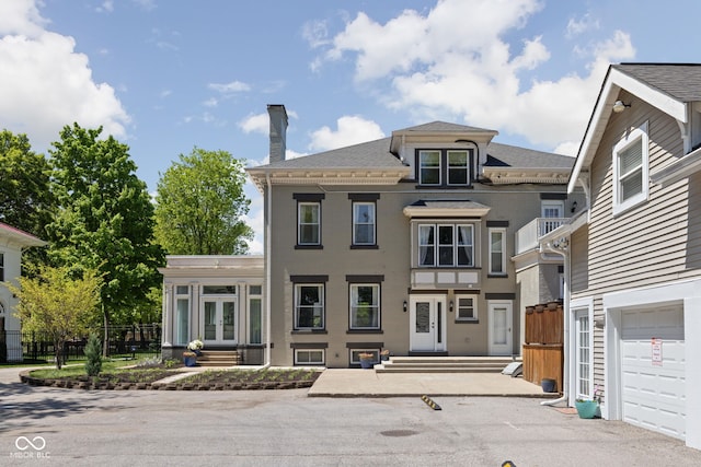 3447 Washington Blvd, Indianapolis, IN 46205 - view of front facade featuring french doors, a chimney, fence, and a garage