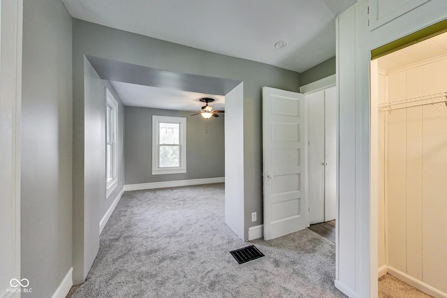 unfurnished bedroom featuring baseboards, carpet floors, and visible vents