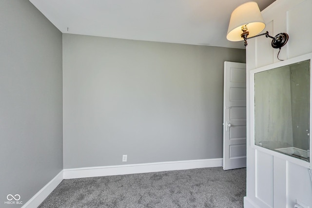 empty room featuring baseboards and carpet flooring
