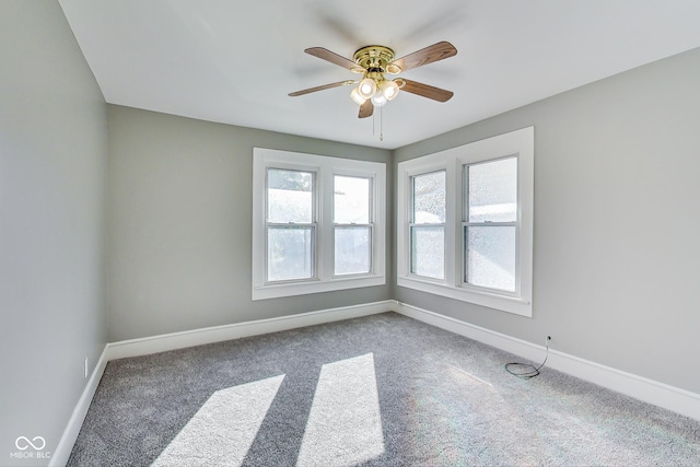 empty room featuring a ceiling fan, carpet, and baseboards