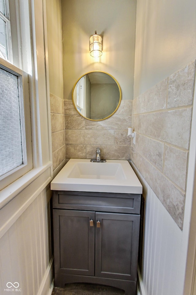 bathroom with tile walls, vanity, and wainscoting