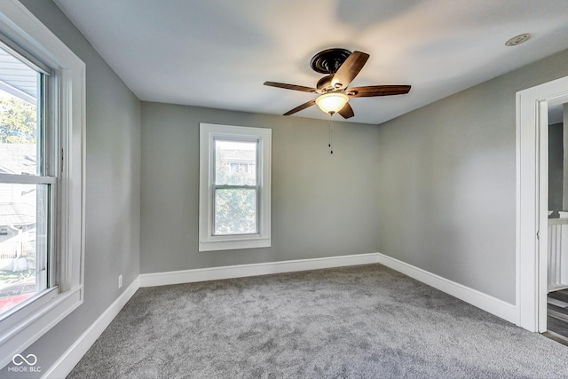 empty room with a ceiling fan, carpet, and baseboards