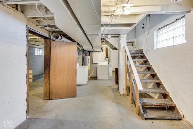 basement with water heater, washer and dryer, and stairway