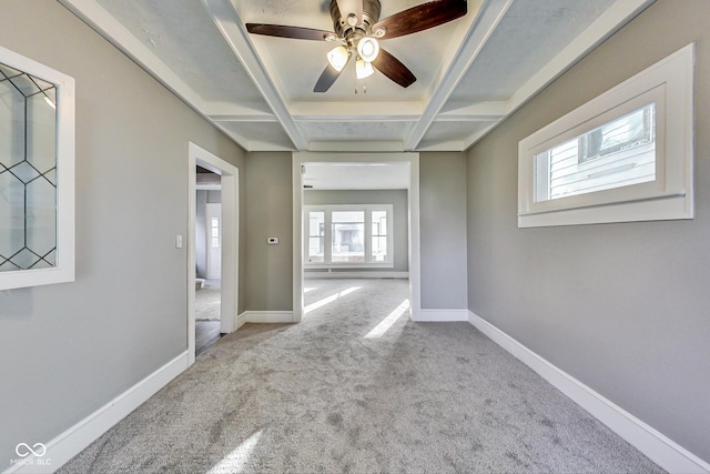 carpeted empty room featuring coffered ceiling, baseboards, beam ceiling, and ceiling fan