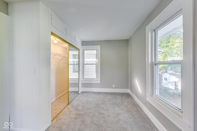 unfurnished bedroom featuring baseboards, carpet floors, and a closet