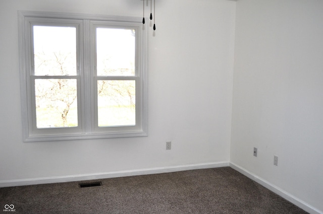 carpeted spare room with visible vents and baseboards