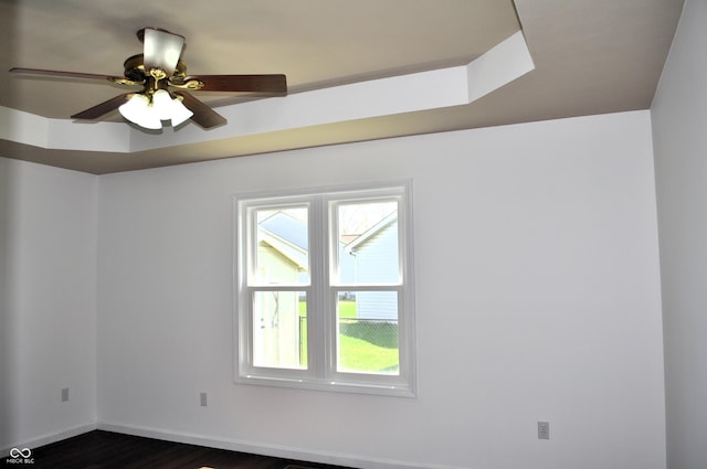 spare room with ceiling fan, baseboards, and dark wood-style flooring