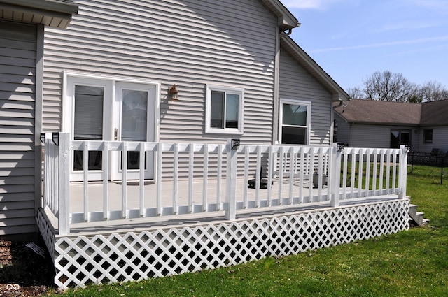 rear view of property with a deck and a lawn