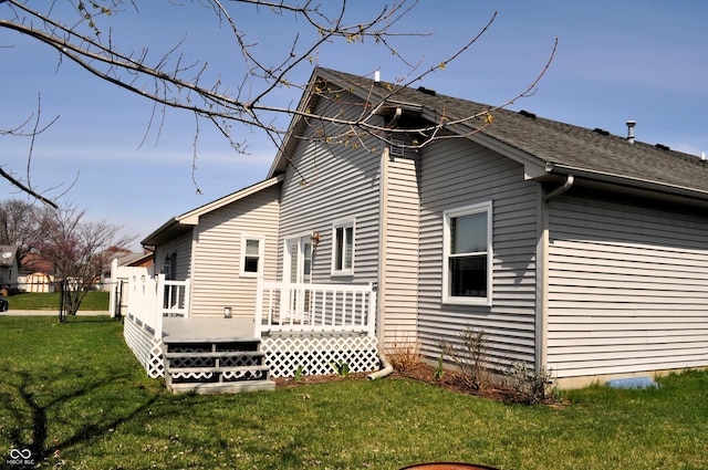 view of home's exterior featuring a yard, fence, and a wooden deck