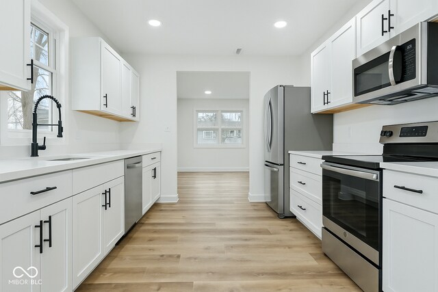 3105 N Tacoma Ave, Indianapolis, IN 46218 - kitchen featuring appliances with stainless steel finishes, a sink, light countertops, white cabinets, and recessed lighting