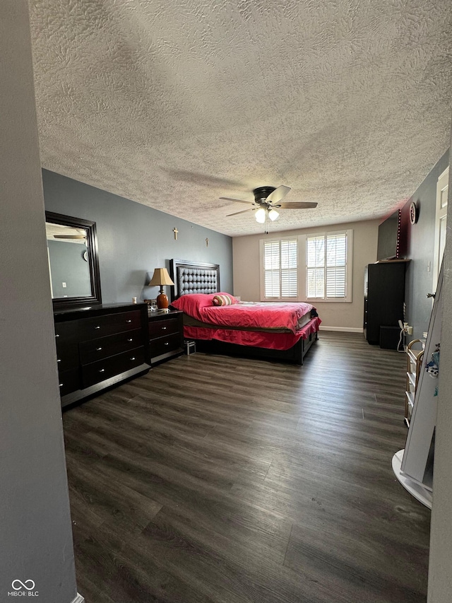 bedroom featuring dark wood-style floors, a textured ceiling, and a ceiling fan