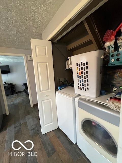 washroom with independent washer and dryer, a textured ceiling, laundry area, and dark wood finished floors