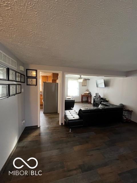 living room with a textured ceiling and wood finished floors