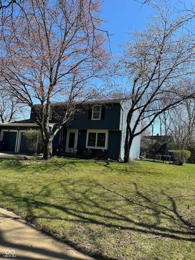 view of front of property with a garage and a front lawn