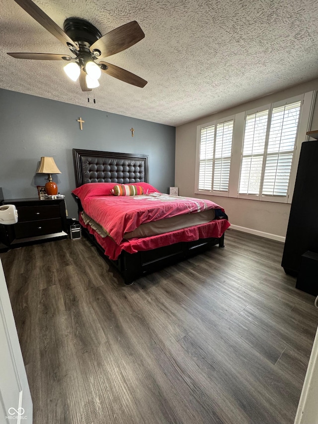 bedroom featuring ceiling fan, baseboards, wood finished floors, and a textured ceiling
