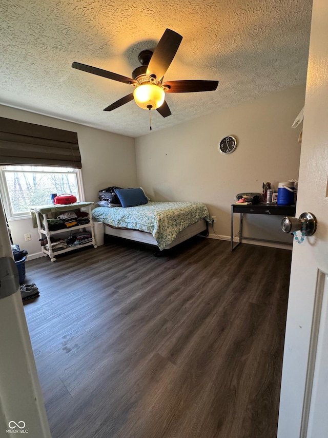 bedroom with ceiling fan, dark wood-style floors, baseboards, and a textured ceiling