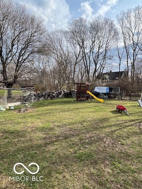 view of yard with fence and a playground