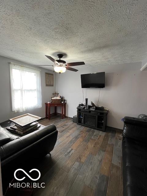 living room featuring a textured ceiling, a ceiling fan, and wood finished floors