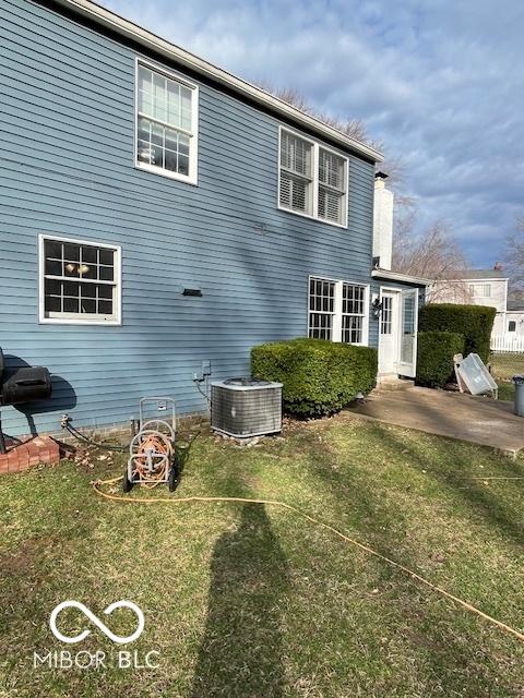 back of property featuring a patio, central AC unit, and a lawn