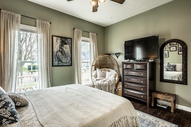 bedroom featuring dark wood finished floors, baseboards, and a ceiling fan