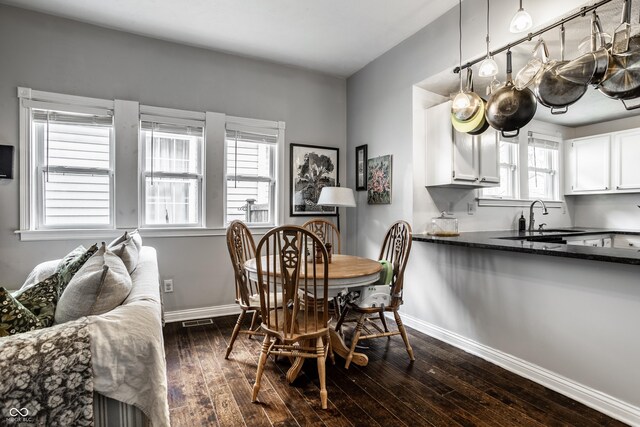 dining area featuring baseboards, visible vents, and dark wood finished floors