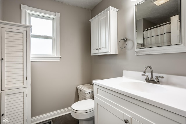 full bath featuring toilet, vanity, tile patterned flooring, and baseboards