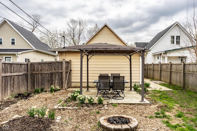 view of yard with a fenced backyard, a fire pit, and a patio