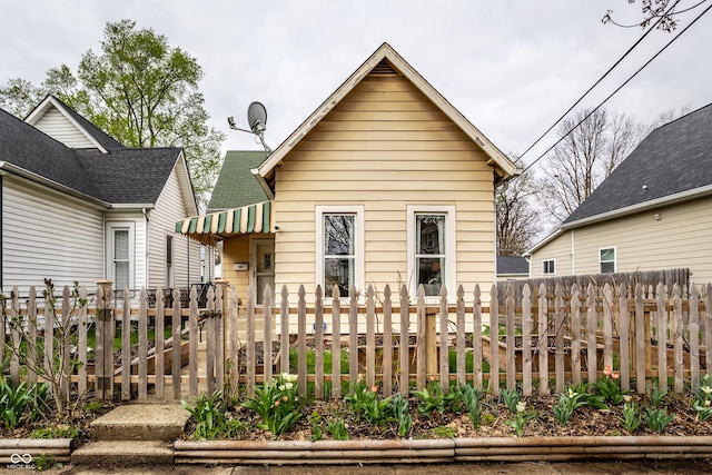 rear view of house with a fenced front yard