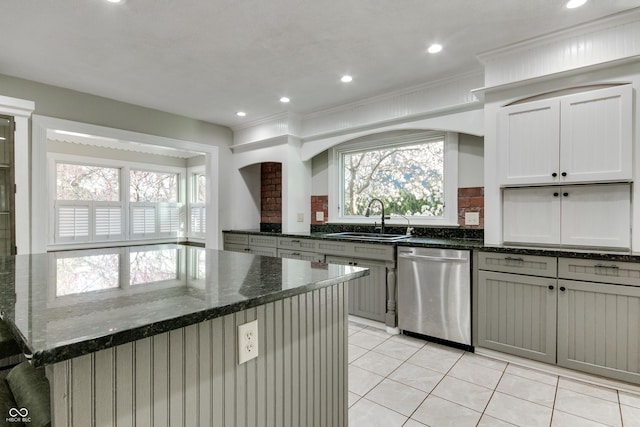 7525 N Meridian St, Indianapolis, IN 46260 - kitchen with light tile patterned flooring, dishwasher, dark stone counters, a sink, and a center island