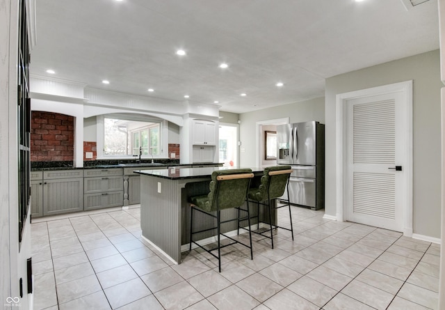 7525 N Meridian St, Indianapolis, IN 46260 - kitchen featuring a kitchen breakfast bar, recessed lighting, stainless steel refrigerator with ice dispenser, a center island, and light tile patterned floors