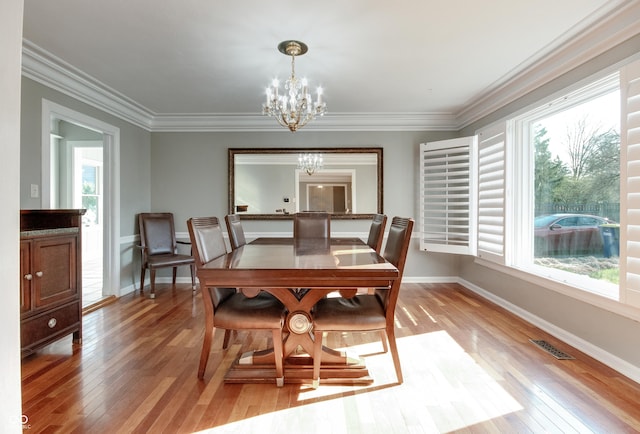 7525 N Meridian St, Indianapolis, IN 46260 - dining area featuring crown molding, a chandelier, light wood-type flooring, baseboards, and visible vents