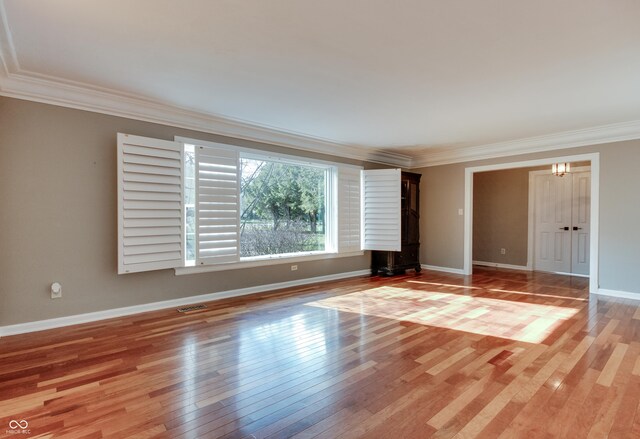 7525 N Meridian St, Indianapolis, IN 46260 - empty room with light wood-type flooring, crown molding, baseboards, and visible vents