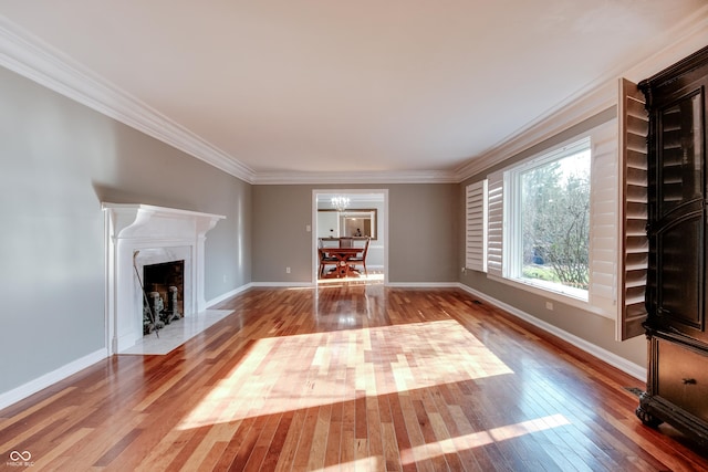 7525 N Meridian St, Indianapolis, IN 46260 - unfurnished living room featuring crown molding, baseboards, a fireplace, an inviting chandelier, and wood-type flooring