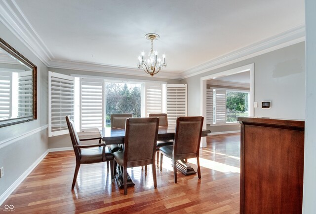 7525 N Meridian St, Indianapolis, IN 46260 - dining room with light wood finished floors, baseboards, ornamental molding, and an inviting chandelier