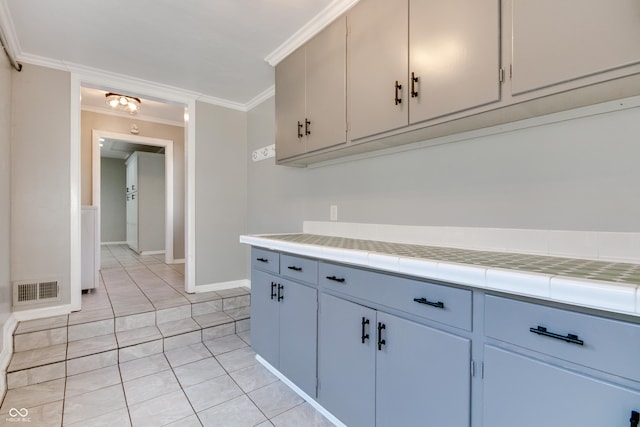 7525 N Meridian St, Indianapolis, IN 46260 - kitchen featuring light tile patterned flooring, ornamental molding, tile counters, and visible vents