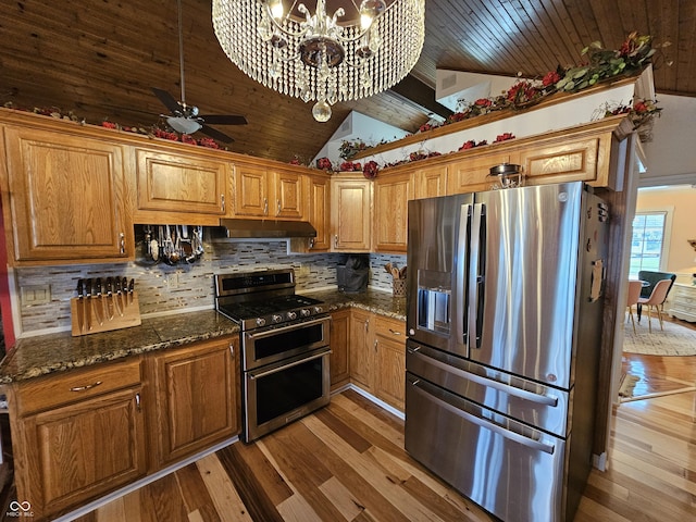 kitchen with backsplash, under cabinet range hood, brown cabinets, stainless steel appliances, and wood finished floors
