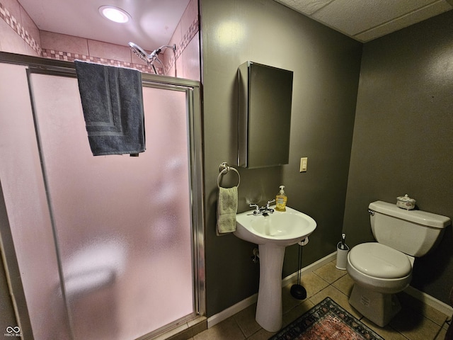 full bath featuring toilet, tile patterned floors, baseboards, and a stall shower