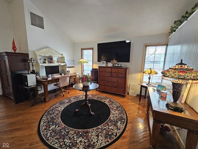 office space with visible vents, wood finished floors, and lofted ceiling