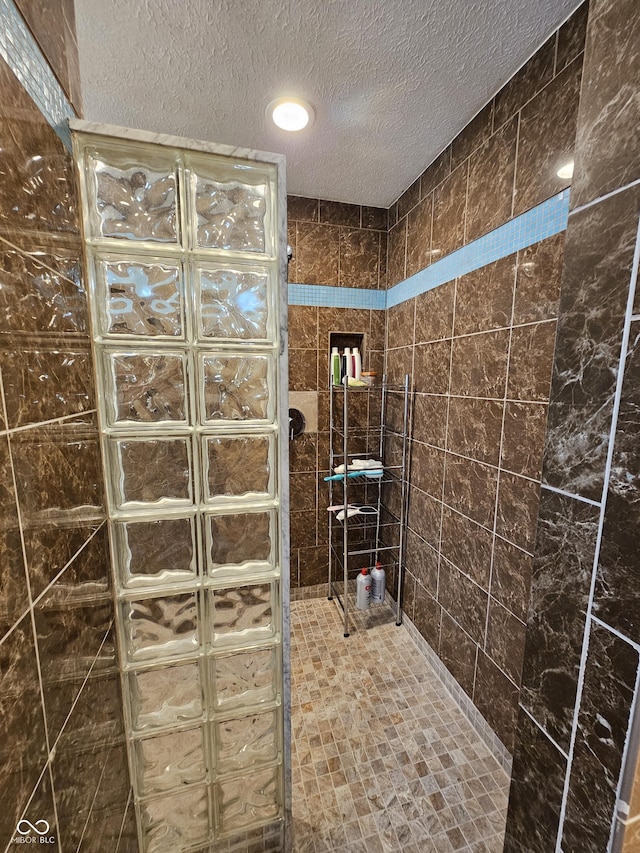 full bathroom featuring a textured ceiling and a walk in shower