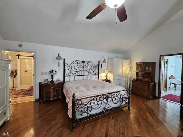bedroom featuring dark wood finished floors, a barn door, a ceiling fan, and lofted ceiling