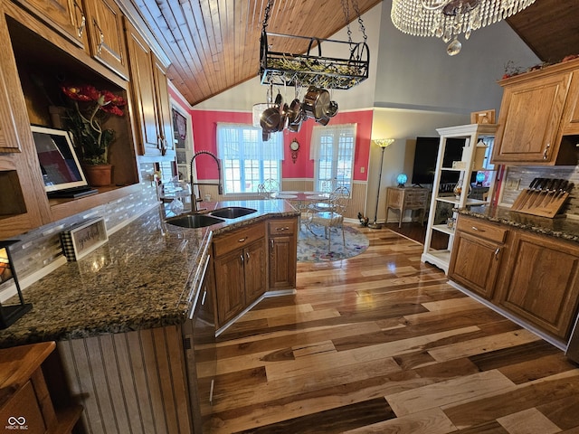 kitchen with a sink, light wood-type flooring, a chandelier, dishwashing machine, and wood ceiling