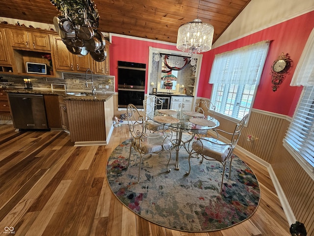 dining space featuring a notable chandelier, a wainscoted wall, lofted ceiling, wood ceiling, and wood finished floors
