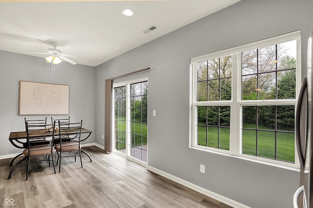 dining area with baseboards, a ceiling fan, light wood finished floors, and visible vents